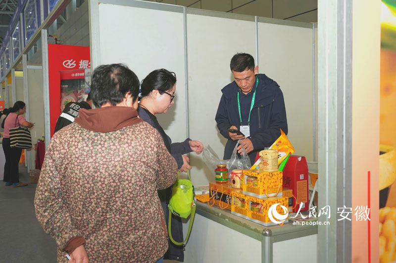 安徽八公山豆制品有限公司展区前游客购买产品。人民网记者 王锐摄